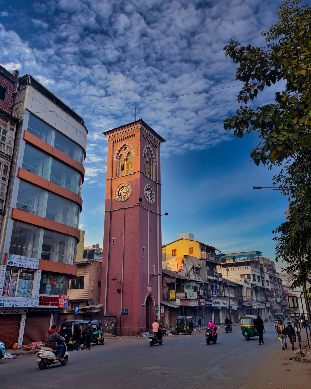 Surat's clock tower rising over a street in the old city, with traffic passing below