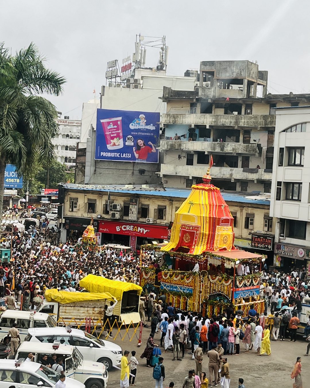 A Rath Yatra chariot moving down a crowded Surat street