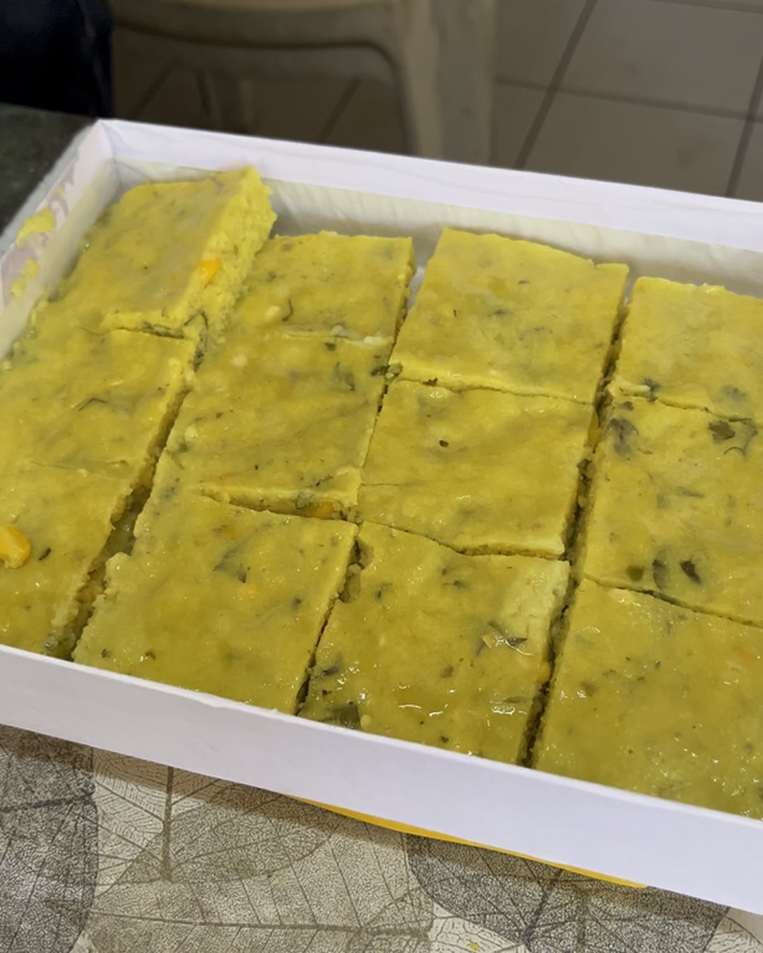 A white tray of freshly cut yellow Gujarati farsan