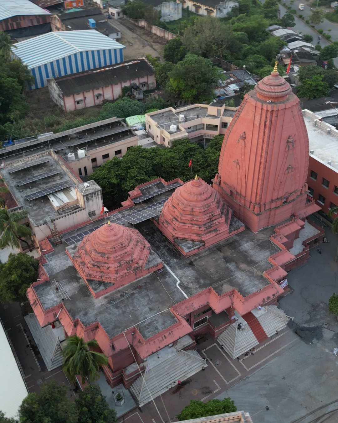 A red stone temple complex in Surat from directly above, its main spire and a row of smaller domes